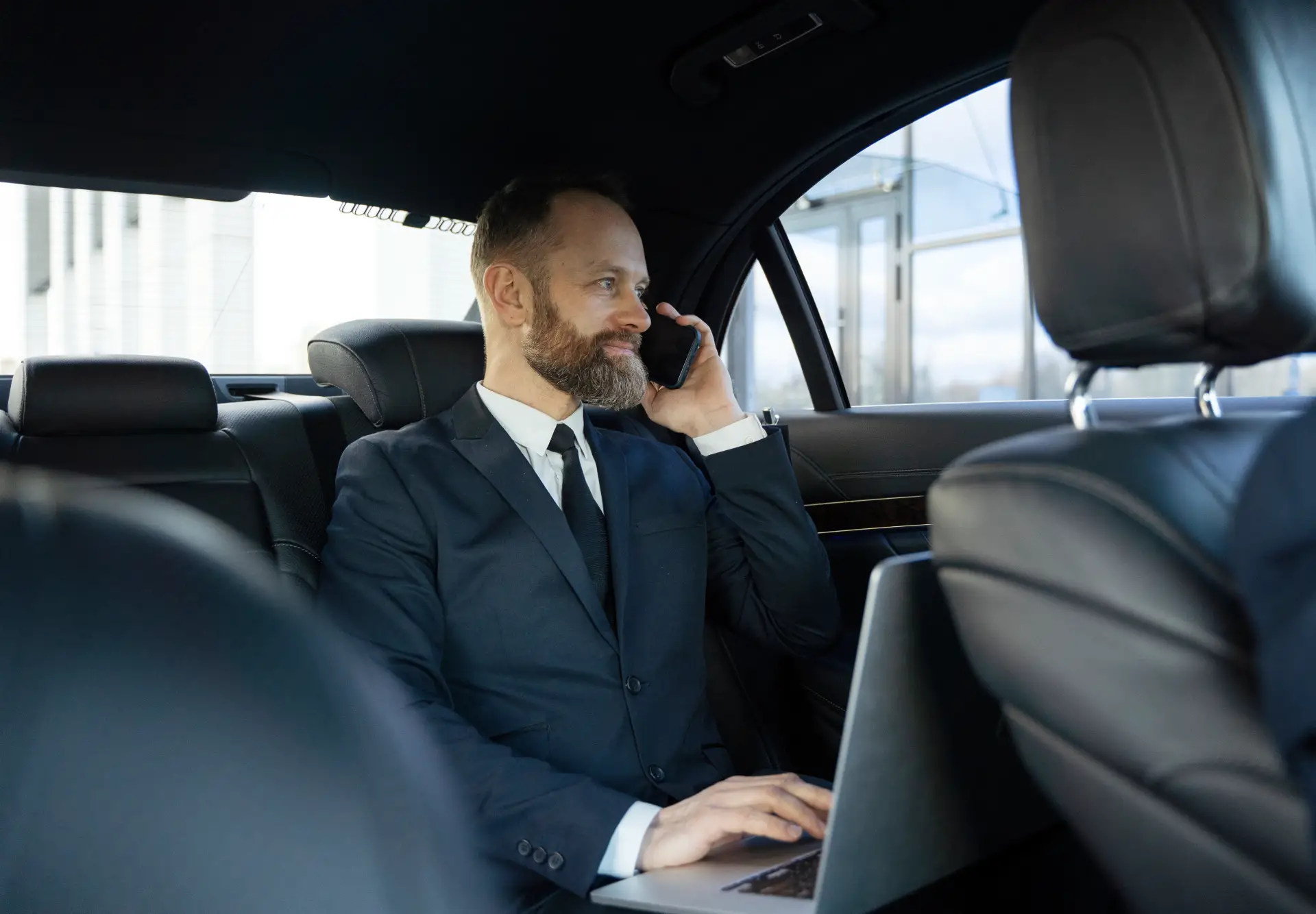 Business chauffeur driving executive in black car Boston